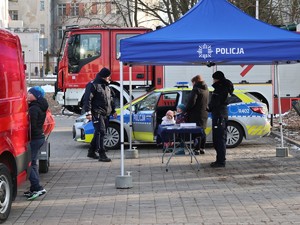 na zdjęciu widoczny jest namiot policyjny w tle wóz strażacki widoczni są również umundurowani policjanci
