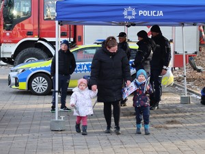 na zdjęciu widoczna jest kobieta z dwójka dzieci w tle widoczny jest namiot policyjny
