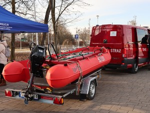 na zdjęciu widoczny jest ponton strażacki i wóz strażacki z boku widoczny  jest część namiotu policyjnego