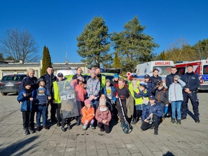 Na zdjęciu umundurowani policjanci stojący wspólnie z dziećmi.