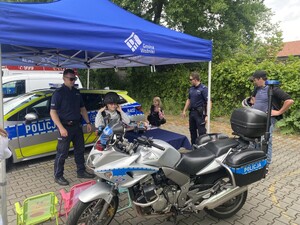 dwóch policjantów radiowóz motocykl policyjny dwoje dzieci