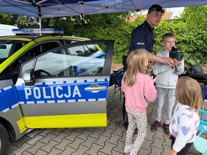 dzieci, policjant, radiowóz sprzęt policyjny do mierzenia prędkości