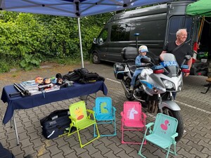 motocykl , dziecko , dorosły mężczyzna stolik z ulotkami i małe krzesełka dla dzieci