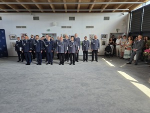 policjanci stoją na baczność w trzech szeregach