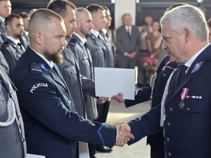 dwóch umundurowanych policjantów podaje sobie dłonie