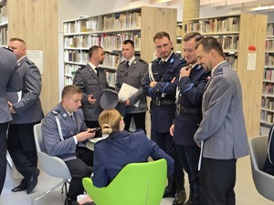 stojących sześciu policjantów dwoje policjantów siedzi przy stoliku
