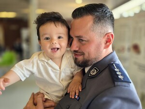 policjant trzyma na rękach małego chłopca