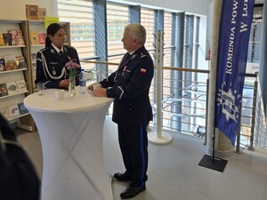 dwoje policjantów stojących przy wysokim  stoliku