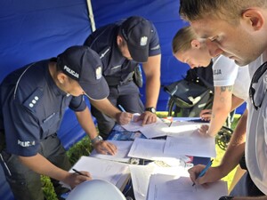 umundurowani policjanci pod namiotem sprawdzają testy